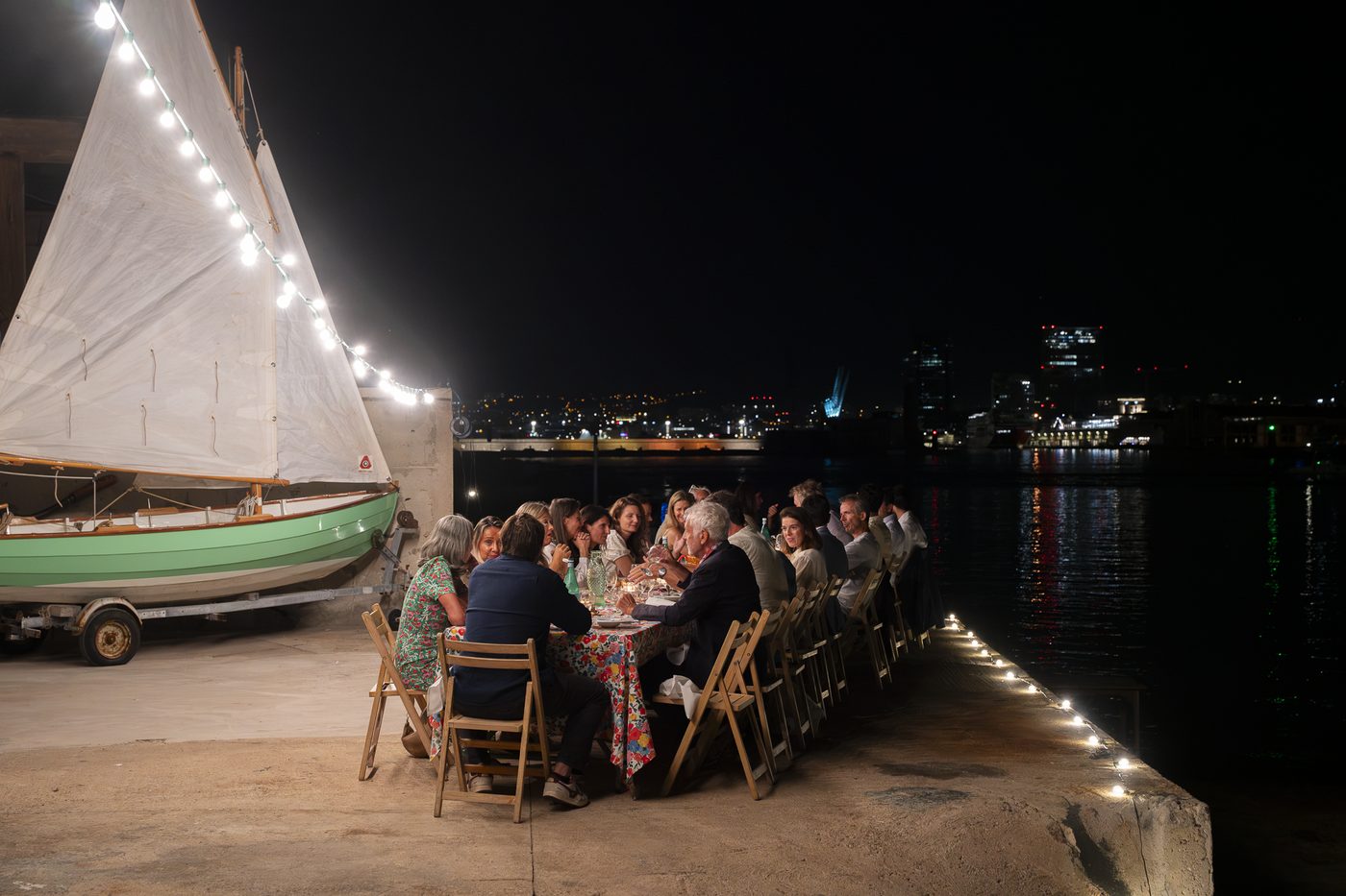 Dîner de nuit Wolk Table sur le chantier naval Borg à Marseille, voilier éclairé de guirlandes au bord de l’eau